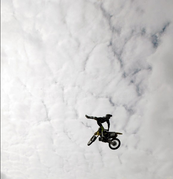 美国极限运动玩家驾摩托车飞越盘旋直升机